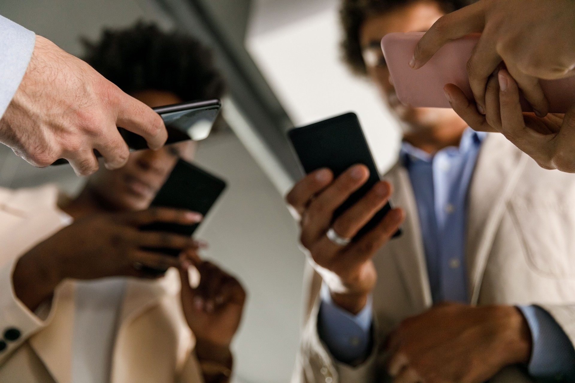 Business people using their smart phones at the office to exchange mobile data